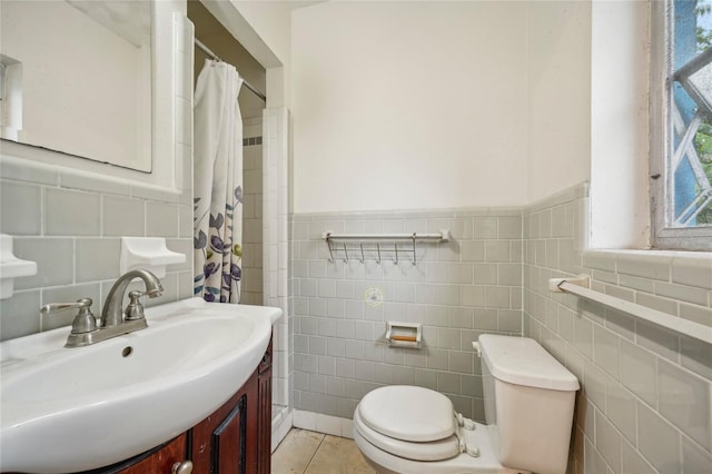 bathroom featuring vanity, a healthy amount of sunlight, tile patterned flooring, and toilet