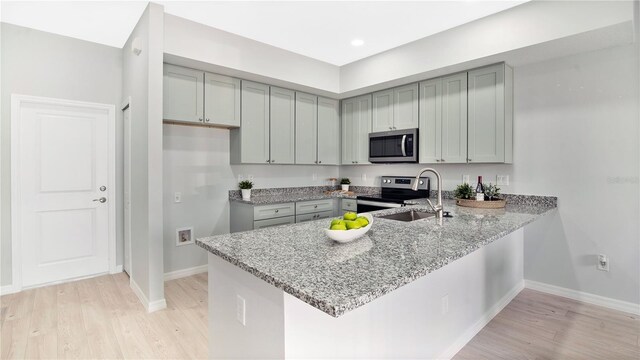 kitchen featuring gray cabinets, stainless steel appliances, and light hardwood / wood-style floors