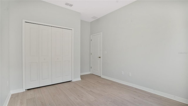 unfurnished bedroom with a closet and light hardwood / wood-style floors