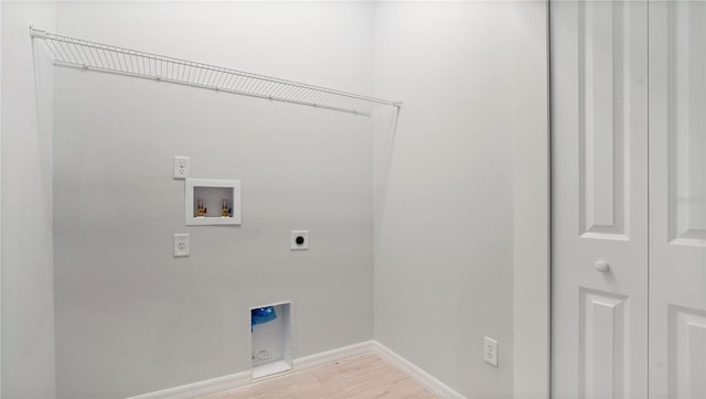 clothes washing area with hookup for an electric dryer, washer hookup, and light hardwood / wood-style floors