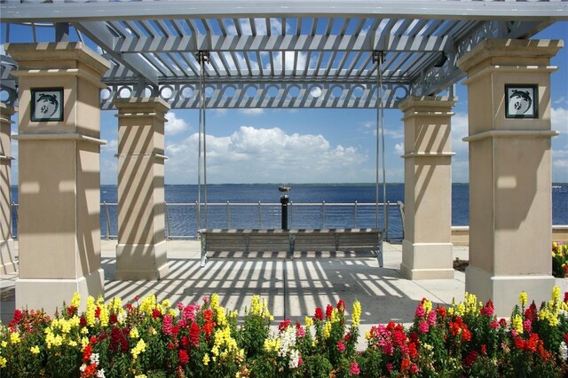 surrounding community featuring a water view and a pergola