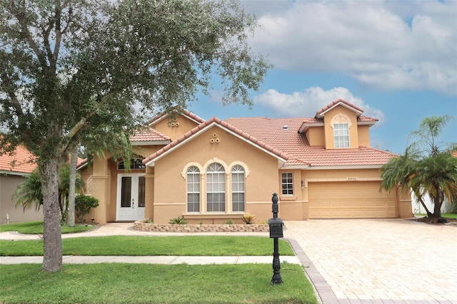 mediterranean / spanish home with a front lawn and french doors