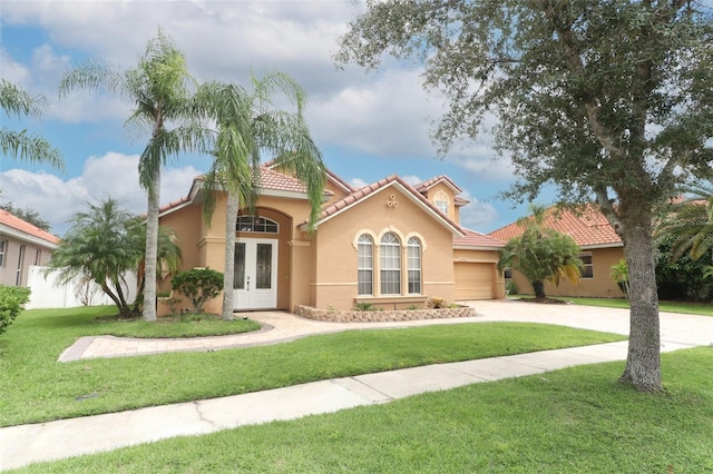 mediterranean / spanish home with a garage and a front yard