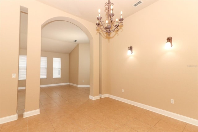 empty room featuring an inviting chandelier and vaulted ceiling