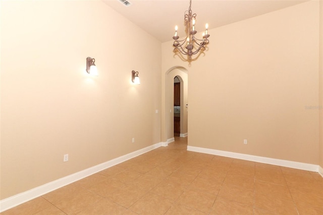 empty room with lofted ceiling, an inviting chandelier, and light tile patterned flooring