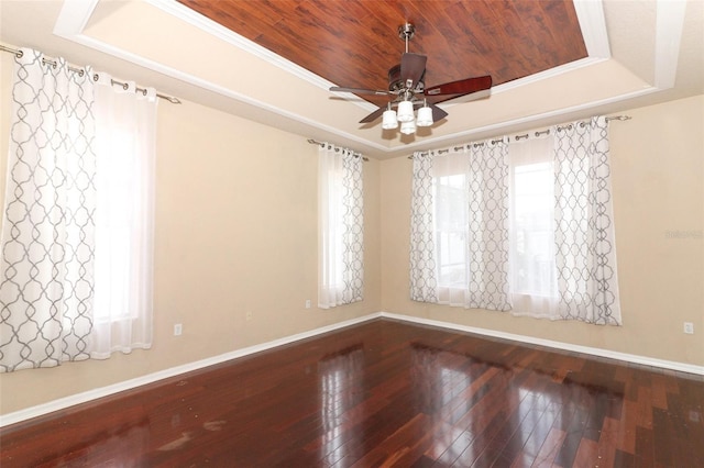 spare room featuring wood-type flooring, a tray ceiling, wood ceiling, crown molding, and ceiling fan