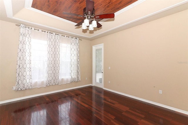 unfurnished room featuring a raised ceiling, ceiling fan, ornamental molding, and hardwood / wood-style floors