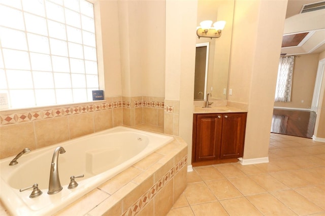 bathroom with vanity, a relaxing tiled tub, and tile patterned flooring