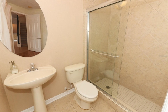 bathroom with an enclosed shower, tile patterned flooring, and toilet