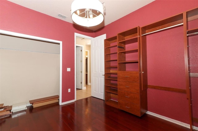 unfurnished bedroom with dark wood-type flooring and a closet