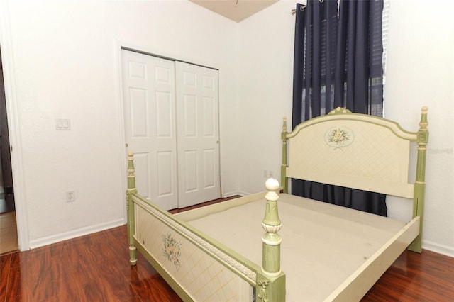 bedroom with dark hardwood / wood-style floors and a closet