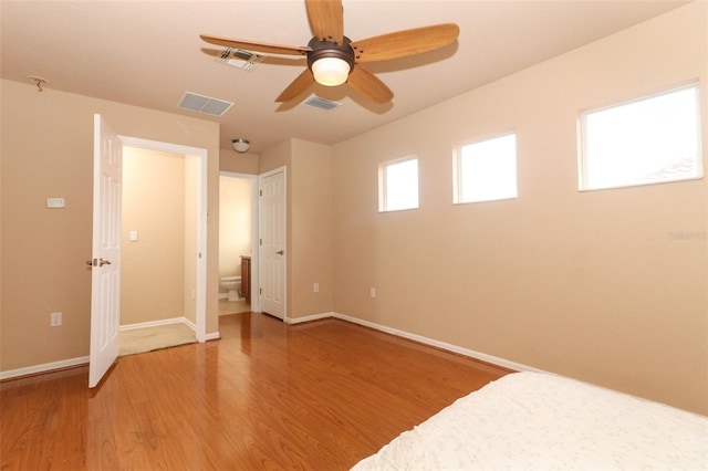 unfurnished bedroom featuring ceiling fan, wood-type flooring, and ensuite bathroom