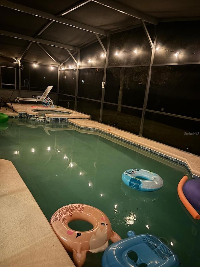 view of pool featuring glass enclosure and an in ground hot tub