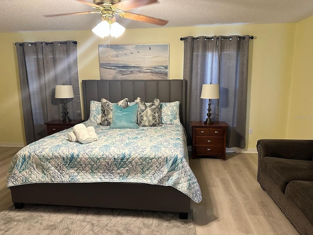 bedroom featuring ceiling fan, light hardwood / wood-style flooring, and a textured ceiling