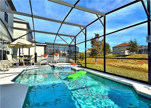 view of pool with glass enclosure and a patio area