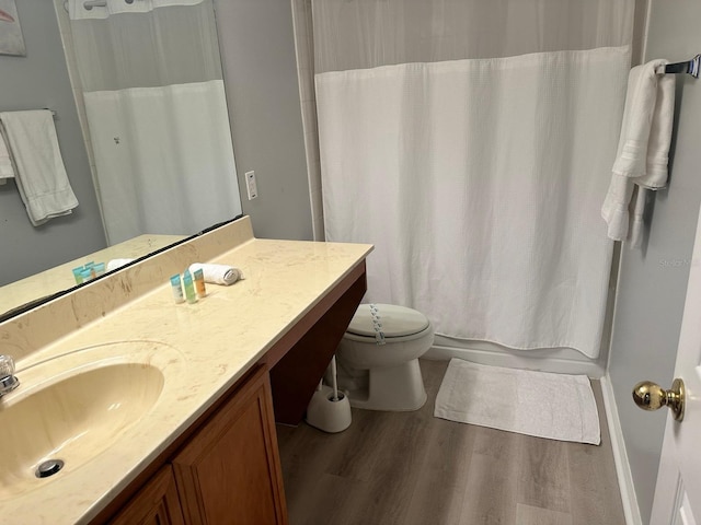 bathroom featuring toilet, vanity, and hardwood / wood-style flooring