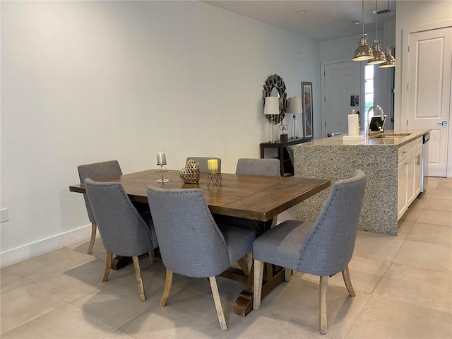 dining area featuring sink and light tile patterned floors