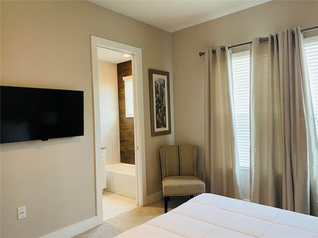 bedroom featuring ensuite bath and light tile patterned floors