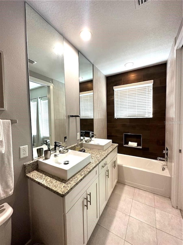 bathroom with a textured ceiling, a bathing tub, wood walls, tile patterned flooring, and dual vanity