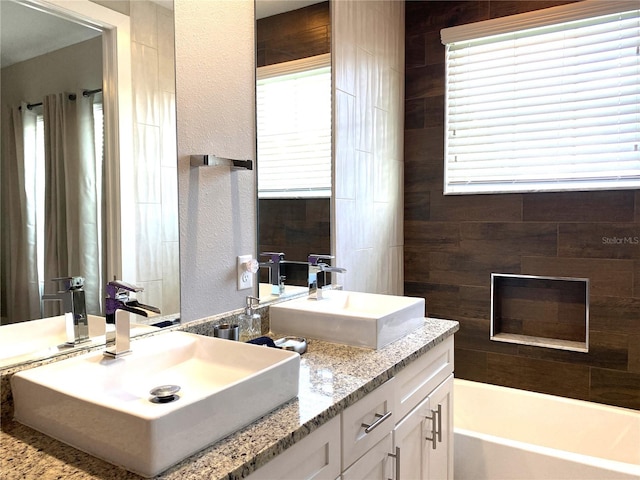 bathroom with double vanity and a washtub