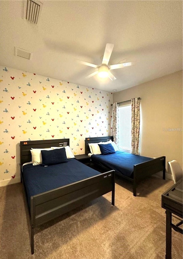 carpeted bedroom featuring ceiling fan and a textured ceiling