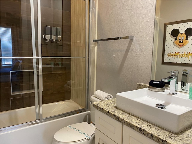 full bathroom featuring vanity, bath / shower combo with glass door, and toilet