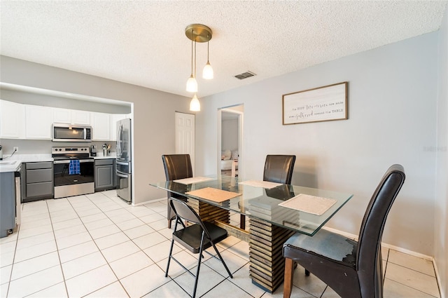 tiled dining area featuring a textured ceiling