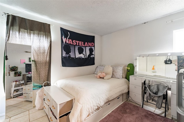 bedroom with a textured ceiling and light tile patterned floors