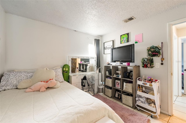 tiled bedroom featuring a textured ceiling