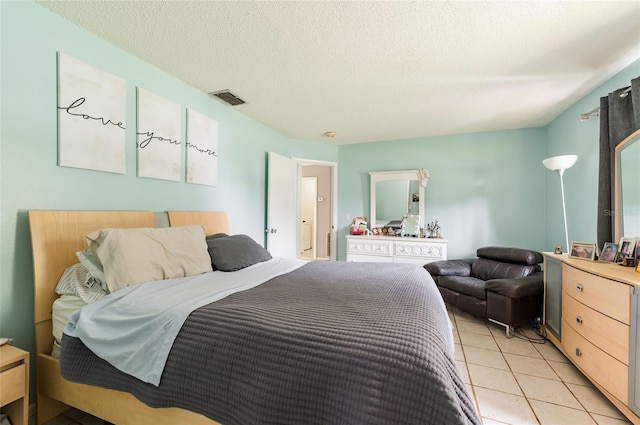 bedroom featuring light tile patterned flooring and a textured ceiling