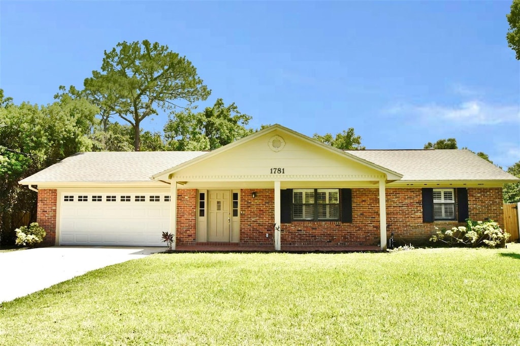 ranch-style house featuring a garage, driveway, brick siding, and a front yard