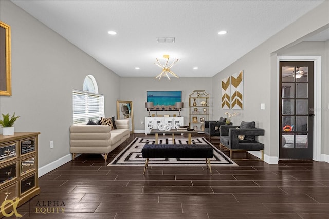 living room featuring a textured ceiling, a notable chandelier, and hardwood / wood-style flooring