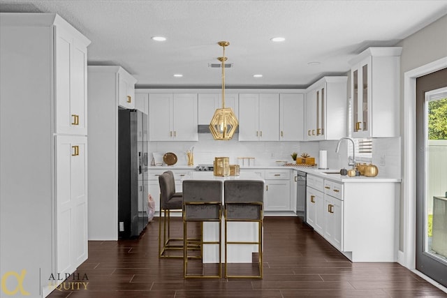 kitchen featuring white cabinetry, dark hardwood / wood-style floors, appliances with stainless steel finishes, and pendant lighting