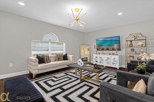 living room with wood-type flooring, a textured ceiling, and an inviting chandelier