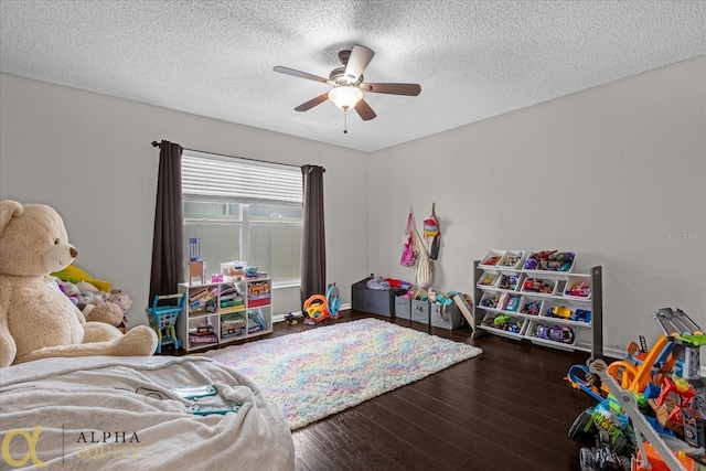 game room featuring ceiling fan, hardwood / wood-style flooring, and a textured ceiling