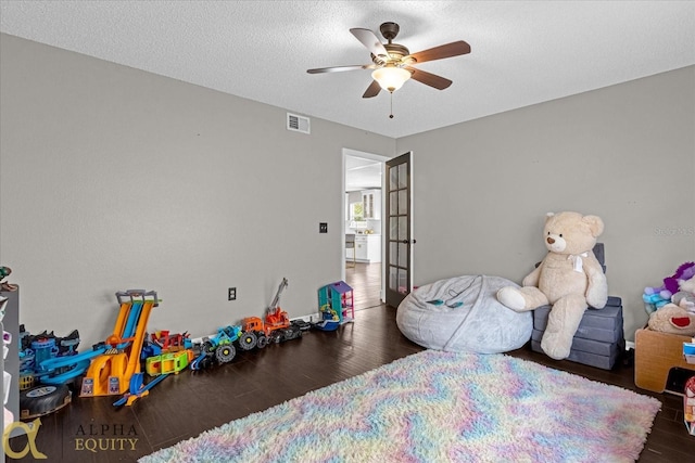 bedroom featuring ceiling fan, a textured ceiling, and dark wood-type flooring