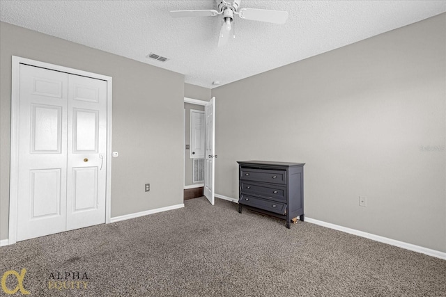 unfurnished bedroom with ceiling fan, a closet, a textured ceiling, and carpet flooring