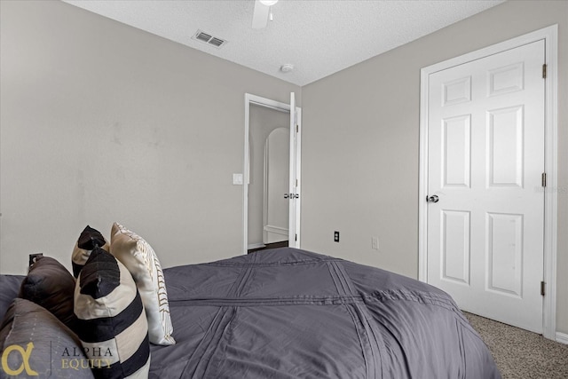 carpeted bedroom featuring a textured ceiling and ceiling fan