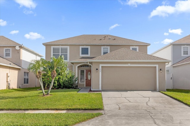 traditional-style home featuring stucco siding, a shingled roof, concrete driveway, a front yard, and a garage