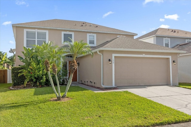 traditional home featuring stucco siding, a shingled roof, an attached garage, a front yard, and driveway