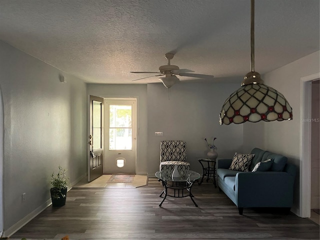 living room with hardwood / wood-style floors, ceiling fan, and a textured ceiling