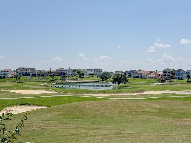 surrounding community with a lawn and a water view