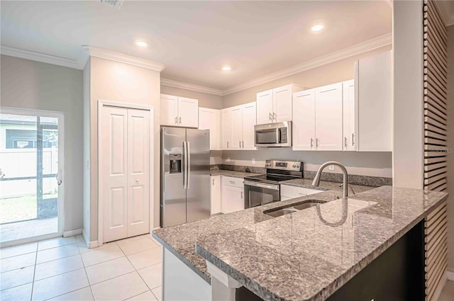 kitchen featuring light tile patterned floors, appliances with stainless steel finishes, white cabinets, stone counters, and kitchen peninsula