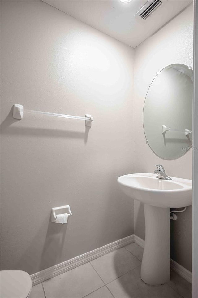 bathroom with toilet and tile patterned flooring