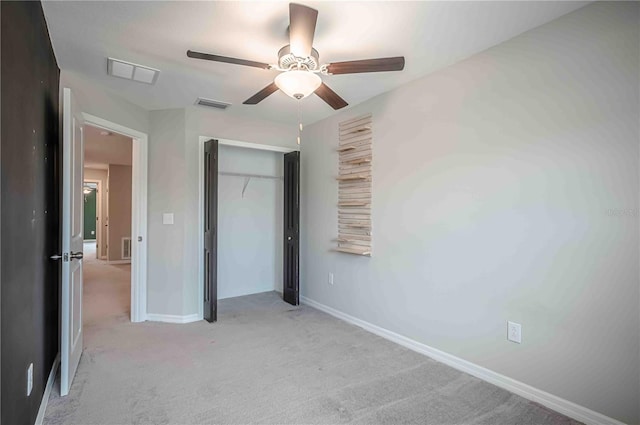 unfurnished bedroom featuring light colored carpet, a closet, and ceiling fan