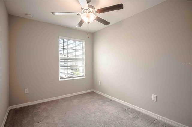 carpeted spare room featuring ceiling fan