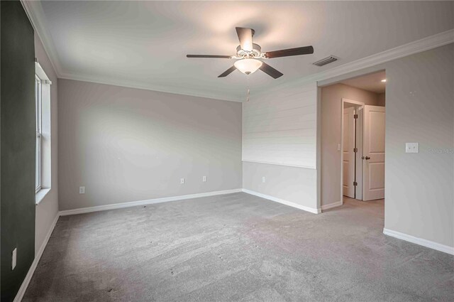 carpeted spare room featuring crown molding and ceiling fan