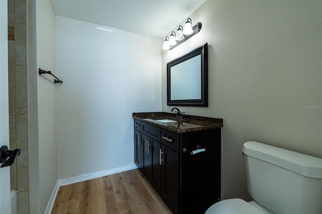 bathroom with vanity, hardwood / wood-style flooring, toilet, and a textured ceiling