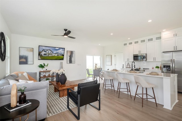 living room with light wood-type flooring and ceiling fan