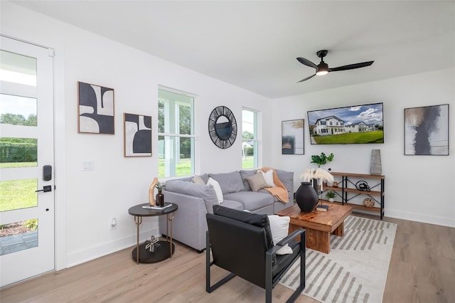 living room with light hardwood / wood-style flooring and ceiling fan